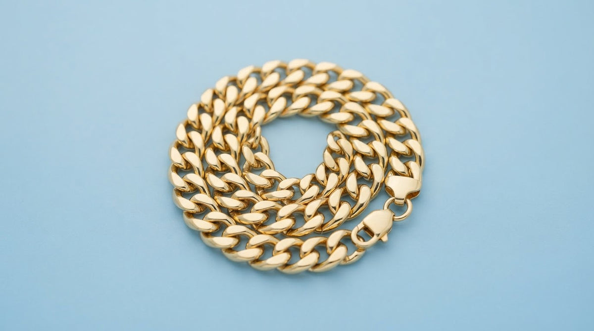 Chunky gold curb chain bracelet on a soft blue background