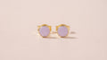 Lilac enamel stud earrings on a blush background
